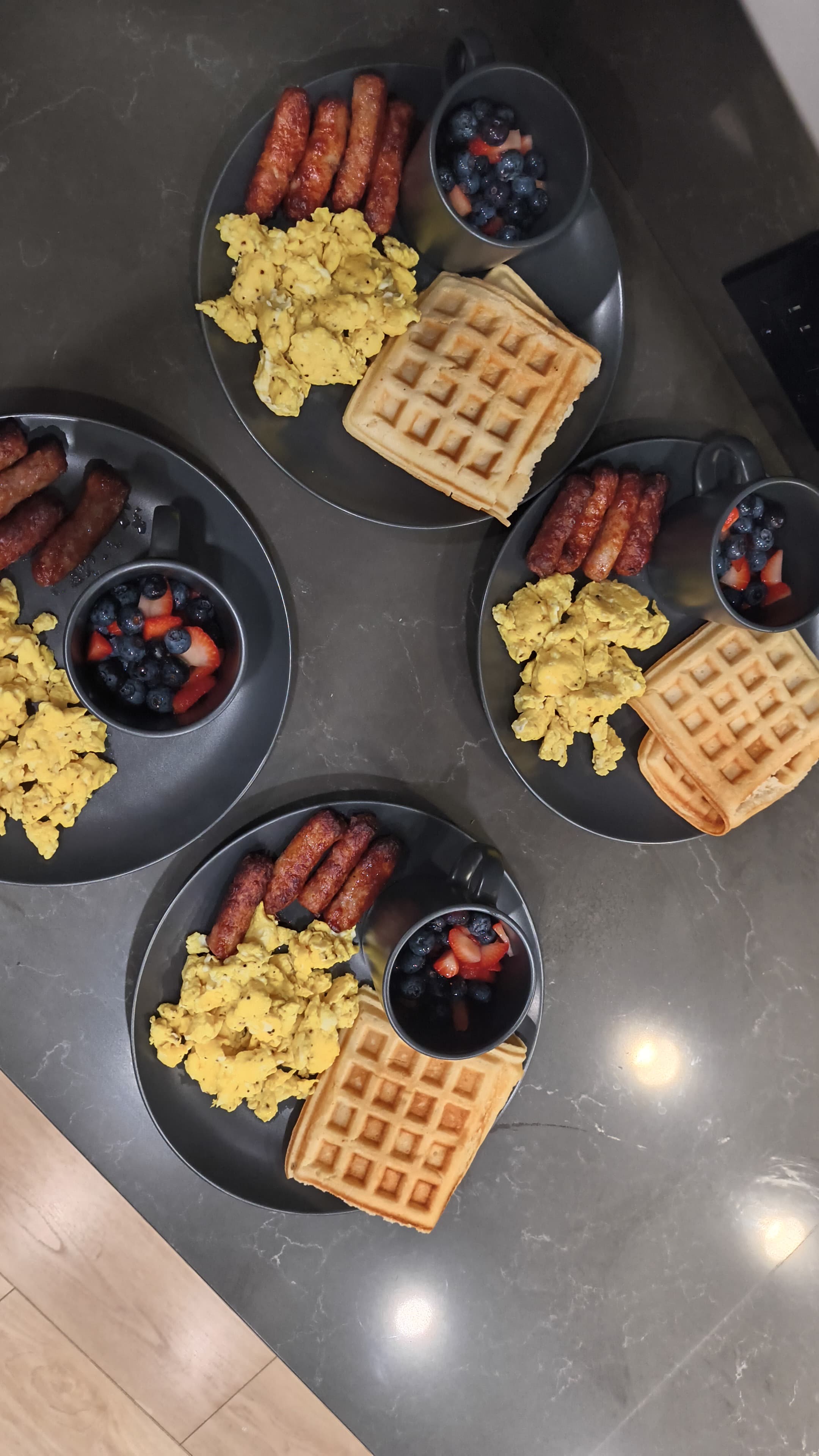 Nutritious breakfast plates with eggs, fruit, and waffles prepared for residents